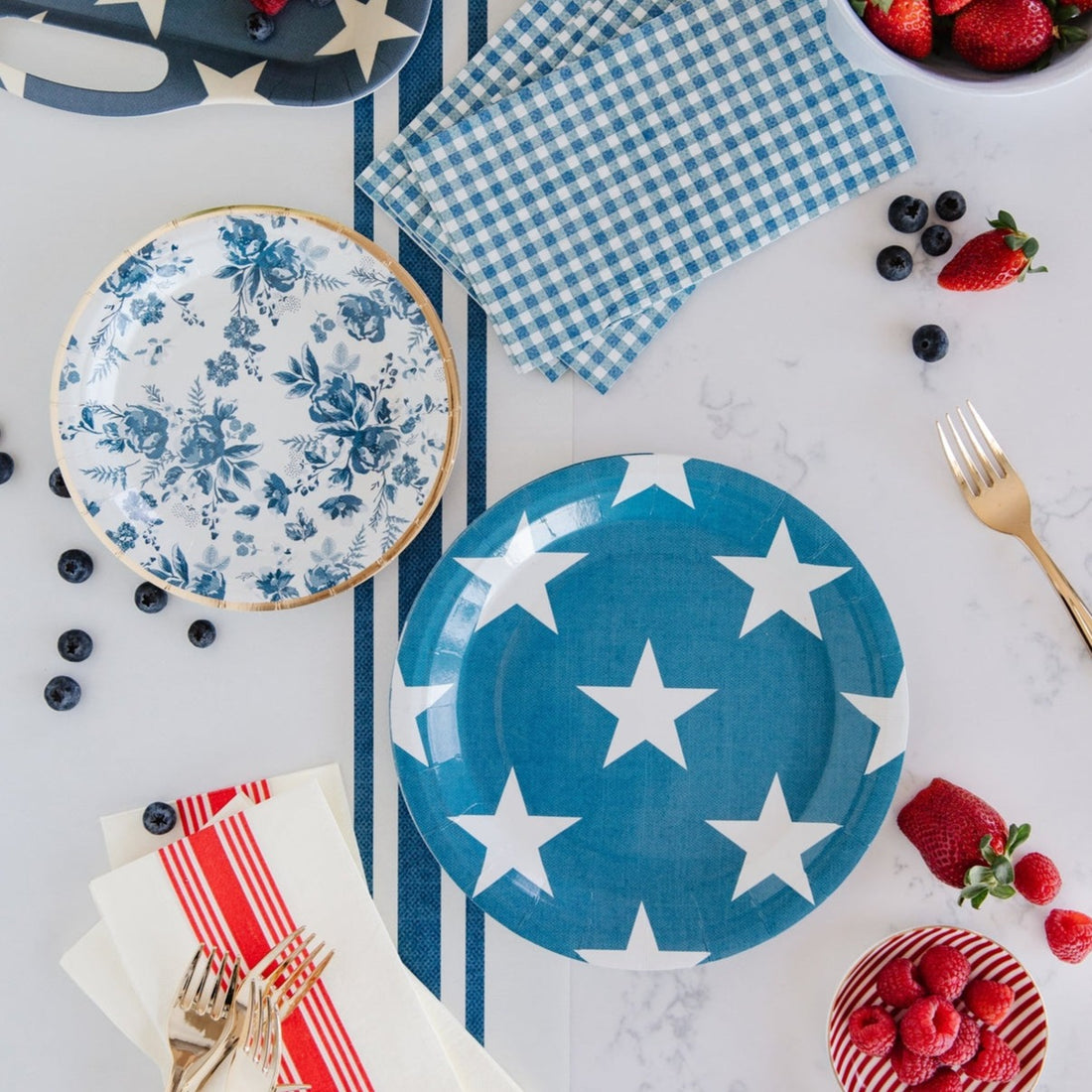 Table setting with paper plates, napkins and forks in a Patriotic theme.