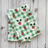 Two green checkered towels with strawberry pattern on a wooden surface.