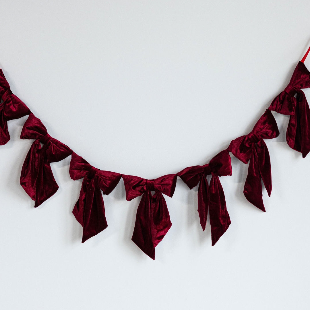 Red velvet ribbon garland on a white background.