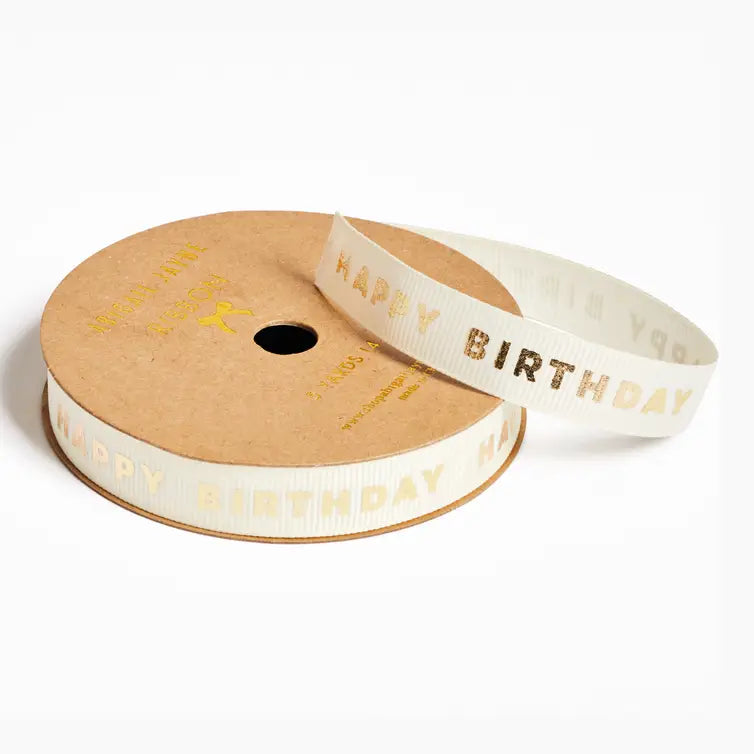 A roll of white ribbon with gold foil &