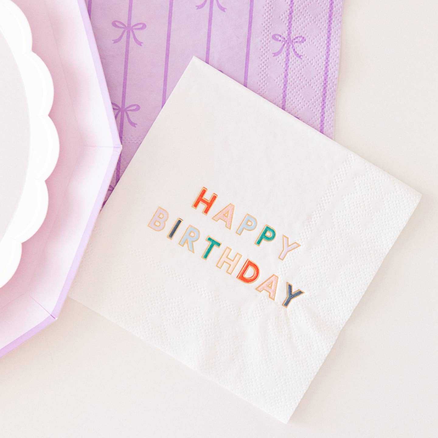 White paper napkin with Happy Birthday printed in various colors on it. 
