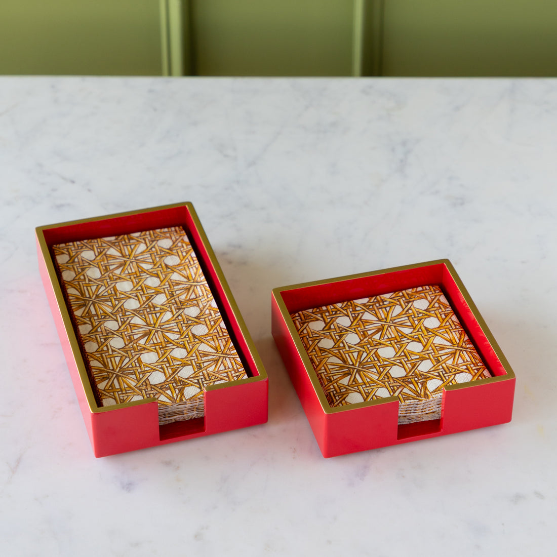 Two Napkin Holders in red with gold trim holding Rattan Weave Napkins.