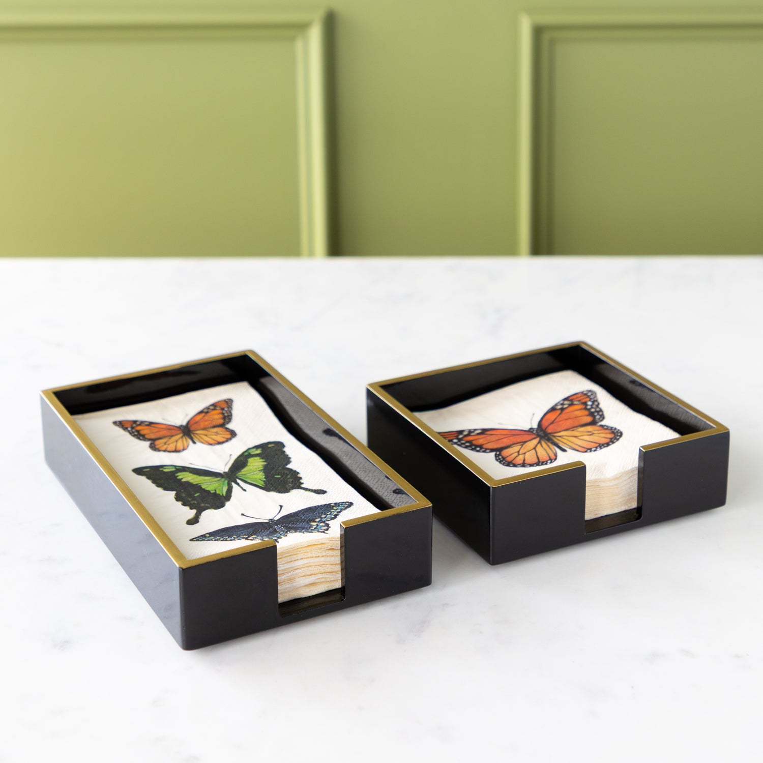 Black Napkin Holders with Gold Trim in a cocktail and guest size with Hester &amp; Cook Butterfly Napkins in them.