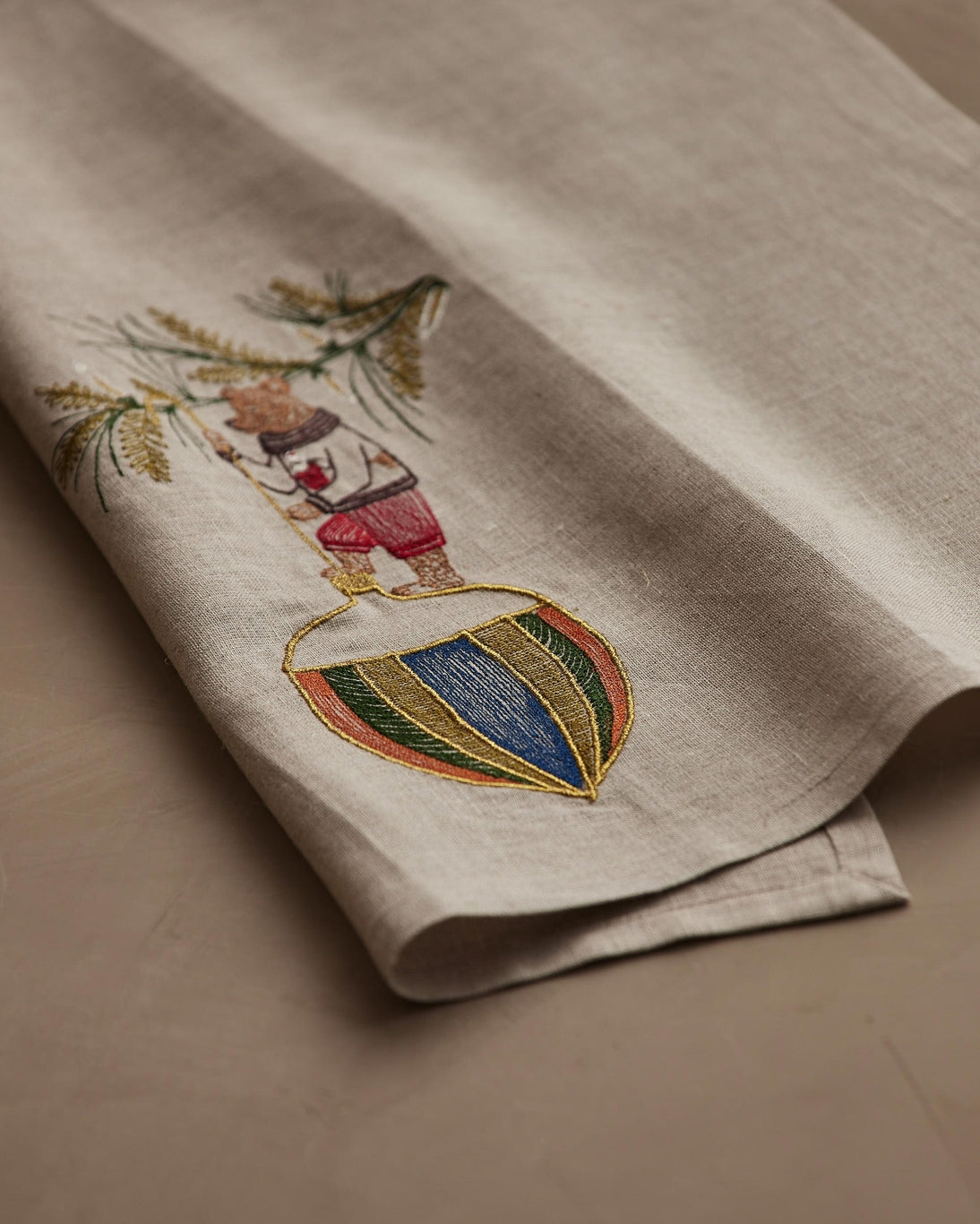 Embroidered towel with a colorful design on a beige background