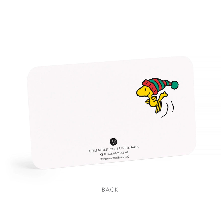 A white square recycling card with rounded corners, shown from the back on a white background. The card features a colorful illustration of Woodstock wearing a red and green striped hat, along with text that reads &