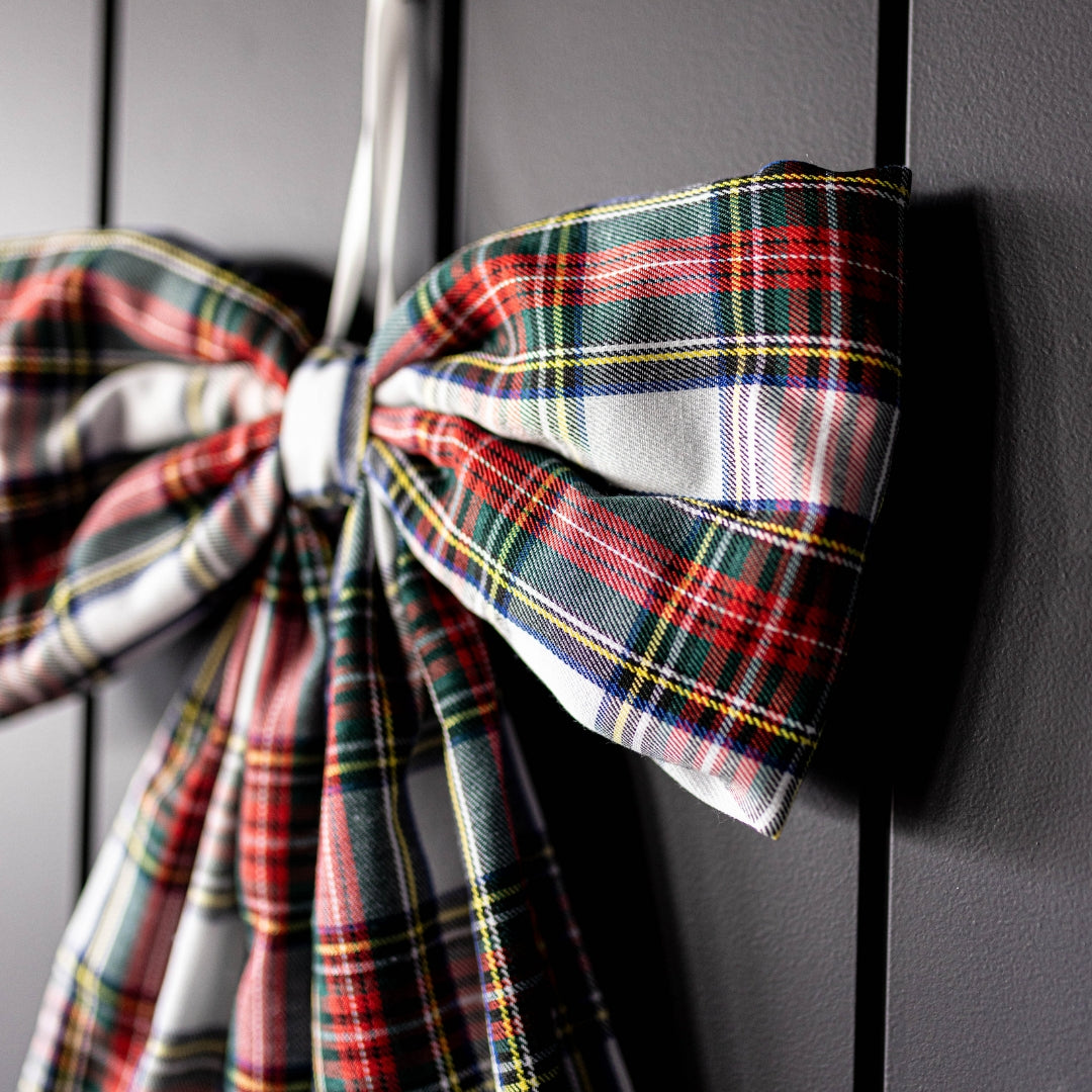 Plaid ribbon tied into a bow on a dark surface