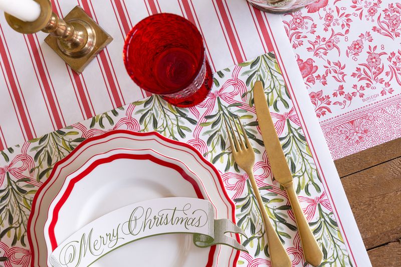 A mistletoe placemat on a holiday place setting. 