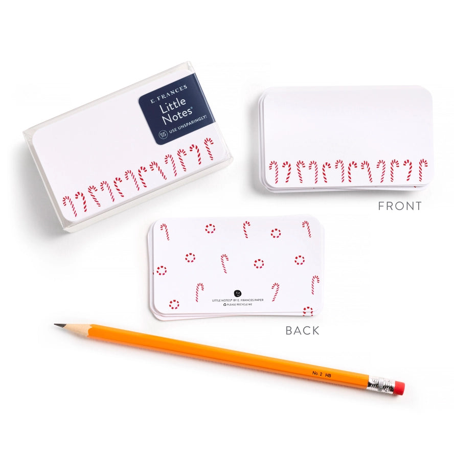 Two small notebooks with candy cane designs, one open showing the front and back, on a white background.