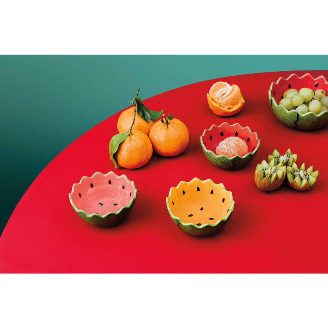 Fruit-shaped bowls on a red and green background.