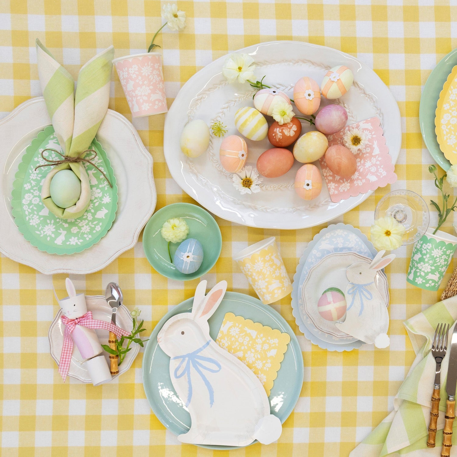 An Easter party table setting featuring Bunny with Bow Plates, easter eggs and decorative elements.