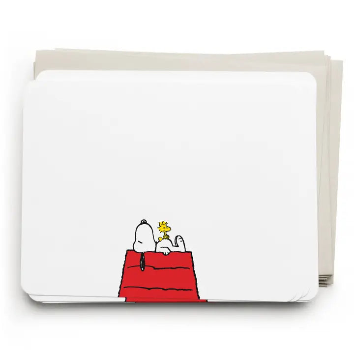A stack of white notepads or memo pads with a small Snoopy and Woodstock illustration on the bottom edge, photographed on a clean white background.