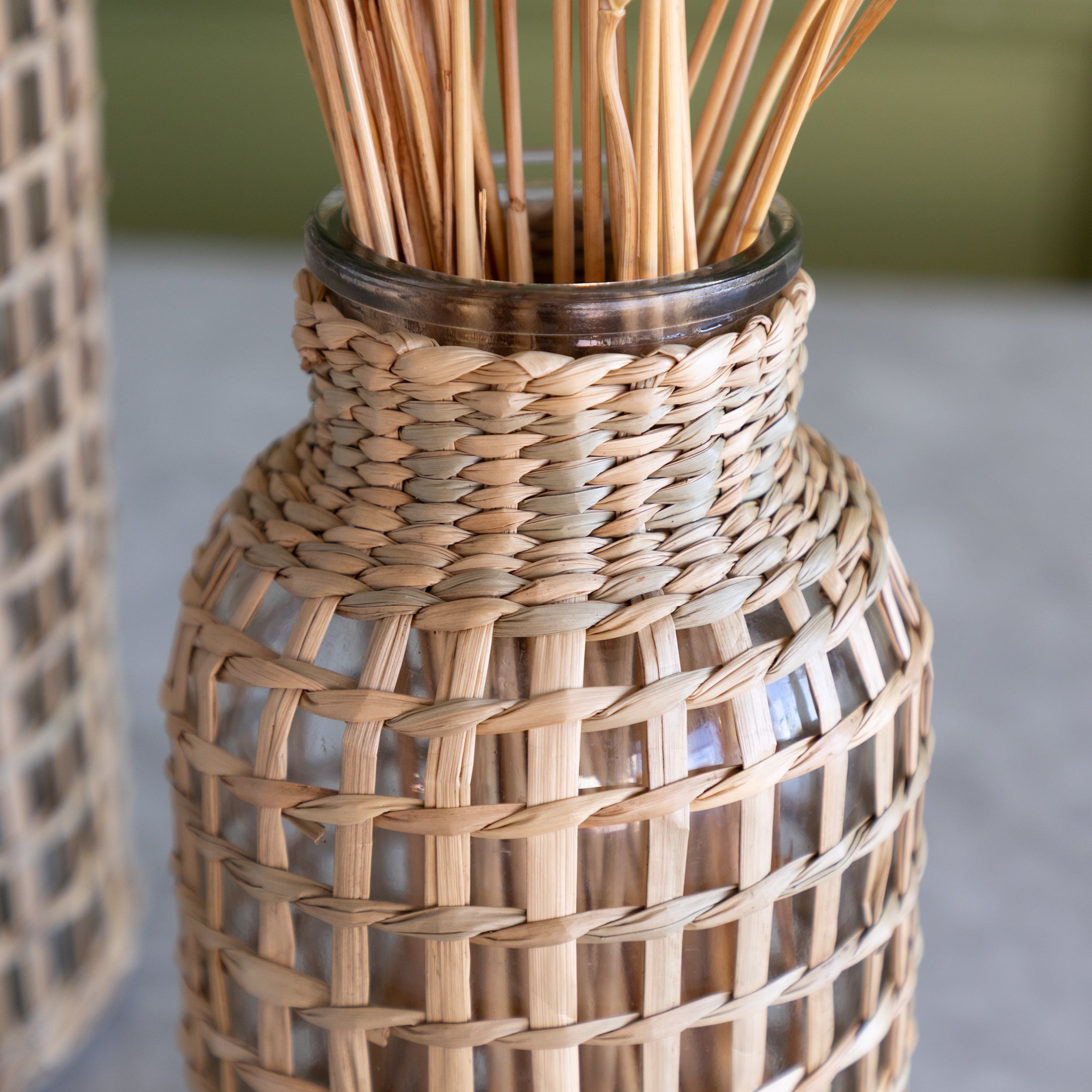 A close up of the small Rattan Wrapped Glass Vase.