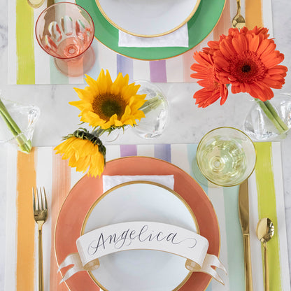 A table setting with favorite flowers in small bouquets and colorful plates, featuring the Qualia Mouth Blown Clear Vase - Exclusively at Hester &amp; Cook.