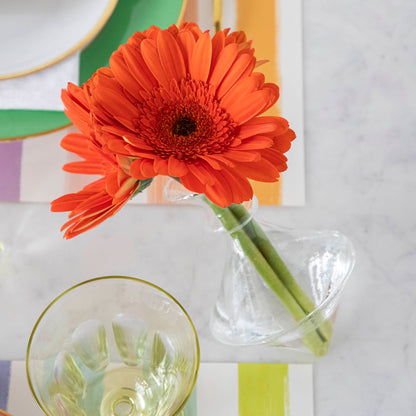 A beautiful orange gerbera flower in a Qualia Mouth Blown Clear Vase - Exclusively at Hester &amp; Cook on a table.