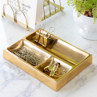 brass catchall tray with assorted paper holders in it