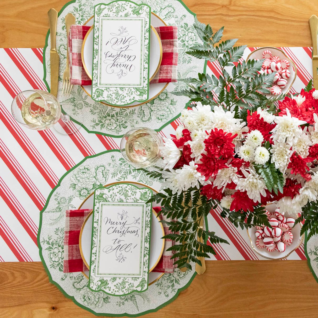 An elegant Christmas table setting with florals, featuring the Die-cut Green Asiatic Pheasants Placemat paired with the Green Asiatic Pheasants Table Card and Peppermint Stripe Runner underneath.