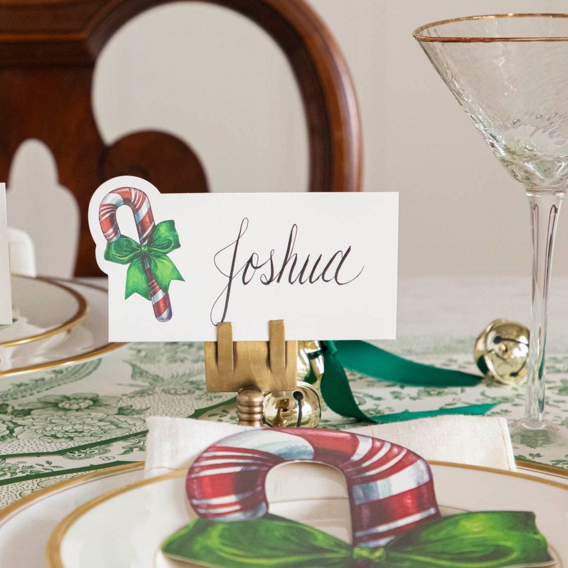 An elegant Christmas table setting featuring the Candy Cane Place Card with &quot;Joshua&quot; written on it, paired with the Candy Cane Table Accent.