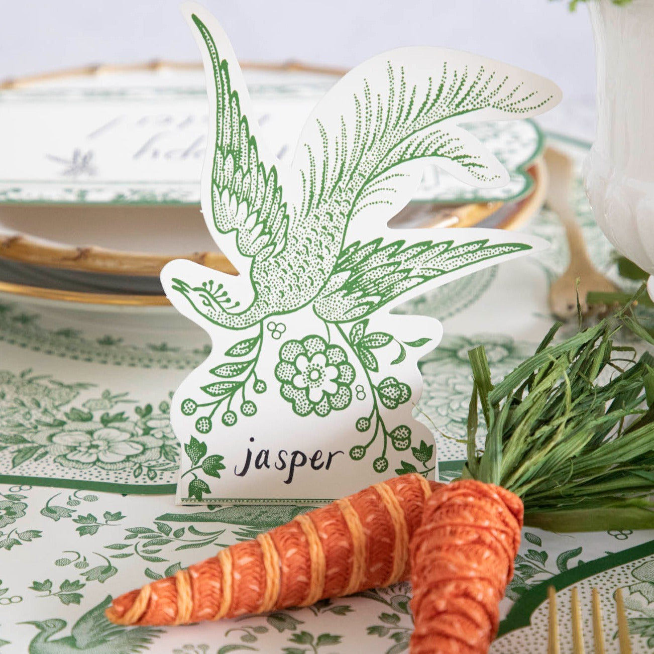 A Hester &amp; Cook Green Asiatic Pheasants place card featuring a beautiful bird and carrots, creating an inviting atmosphere for guests.