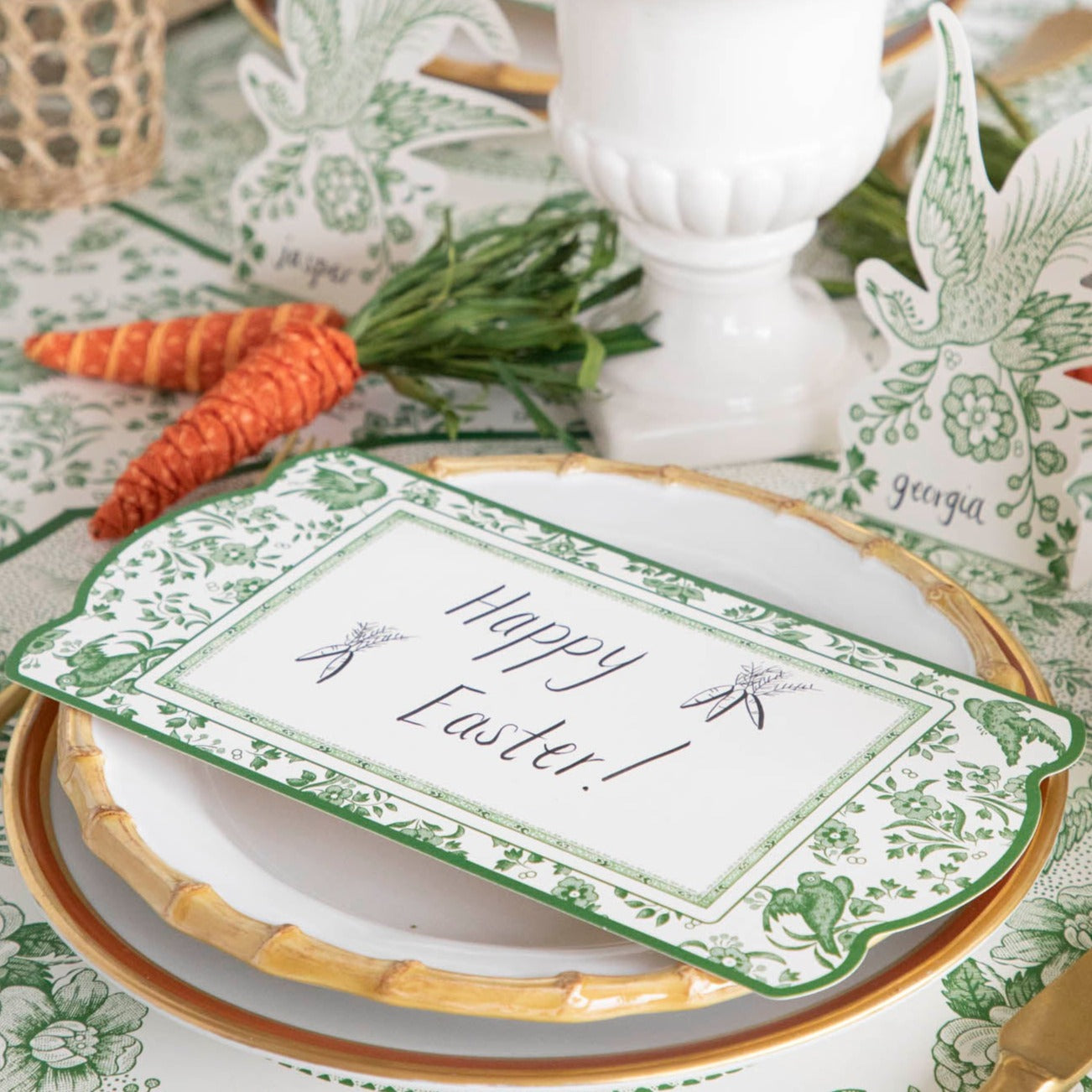 A table setting with green and white plates and a Hester &amp; Cook Green Regal Peacock Table Card.