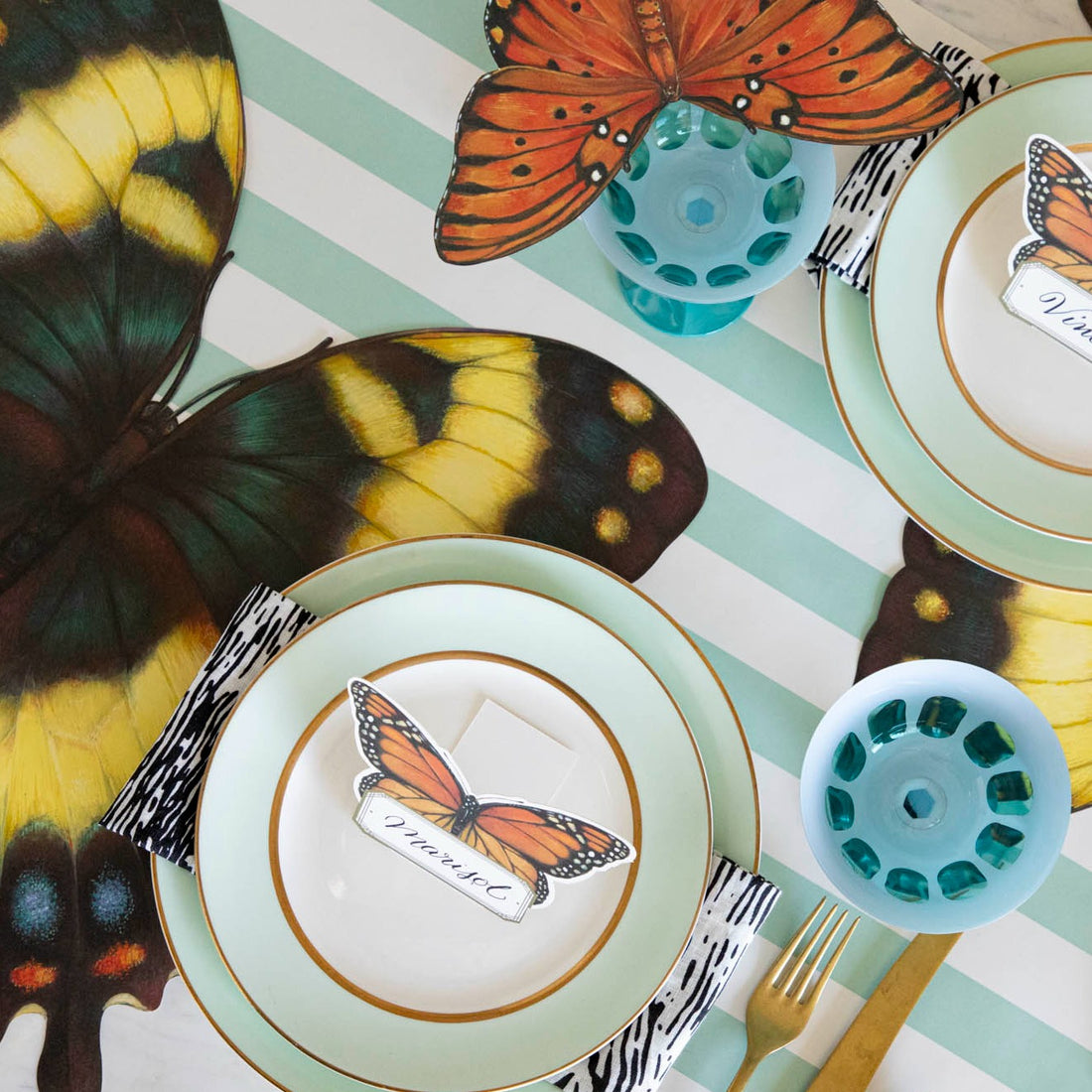 An elegant butterfly-themed table setting featuring the Die-cut Butterfly Placemat, from above.