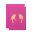 A pink card featuring the silhouette of two mirrored birds in solid gold leaf.
