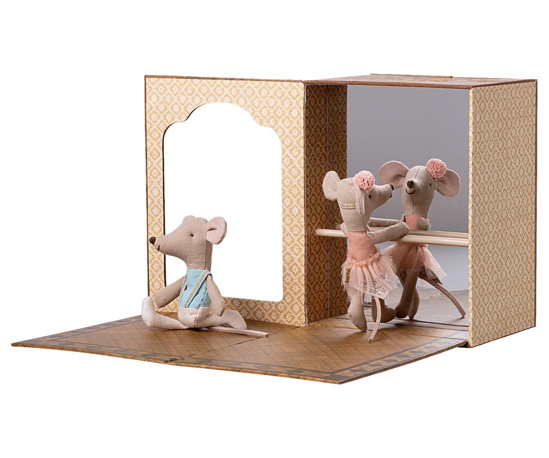 Toy mouse figures in a display case that looks like a ballet studio with a white background.  