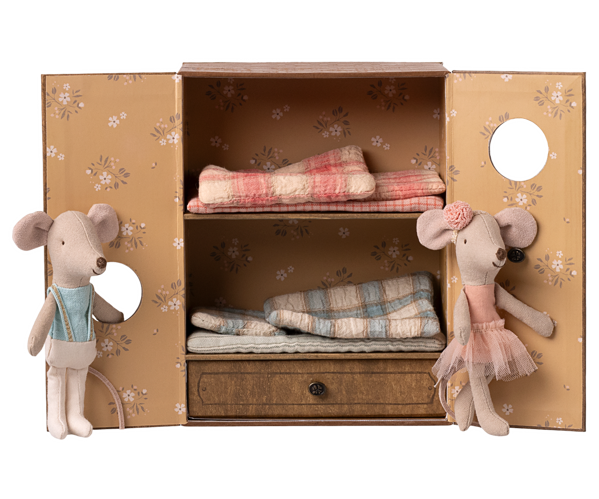 Toy mice with a wooden cabinet containing fabric rolls on a white background.