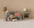 Two toy mice in a miniature living room setting with furniture and decor.