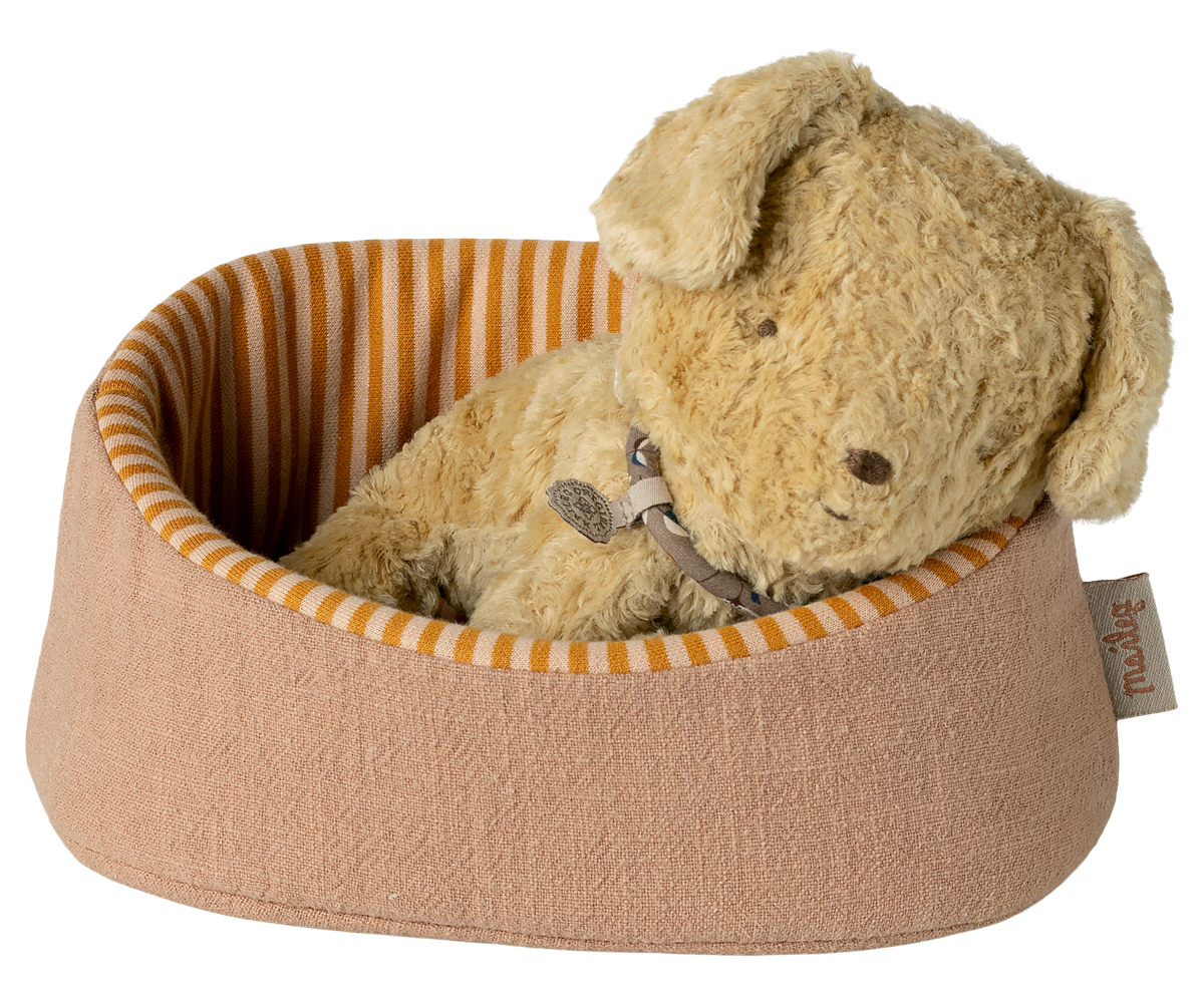 Plush dog toy in a brown pet bed with orange stripes on a white background