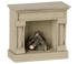 A miniature fireplace mantel figurine in a distressed beige finish, featuring a small stack of faux logs inside the fireplace opening, shown against a plain white background.