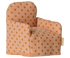 A small fabric armchair with a warm beige base and brown polka dots, photographed on a plain white background. A small fabric brand tag is visible on the right side.