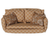 A vintage-style two-seater miniature sofa with rolled arms upholstered in a beige fabric with a brown sunflower pattern, featuring two matching floral throw pillows.