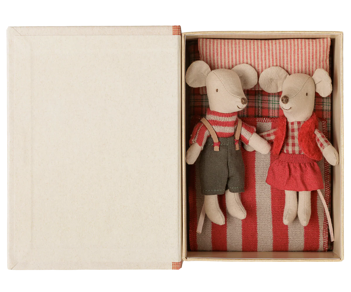 A pair of vintage-style paper mouse dolls in a cream-colored gift box. The left mouse wears a red-and-white striped sweater and dark gray trousers, while the right mouse wears a red vest over a red-and-white checkered shirt and a red dress.