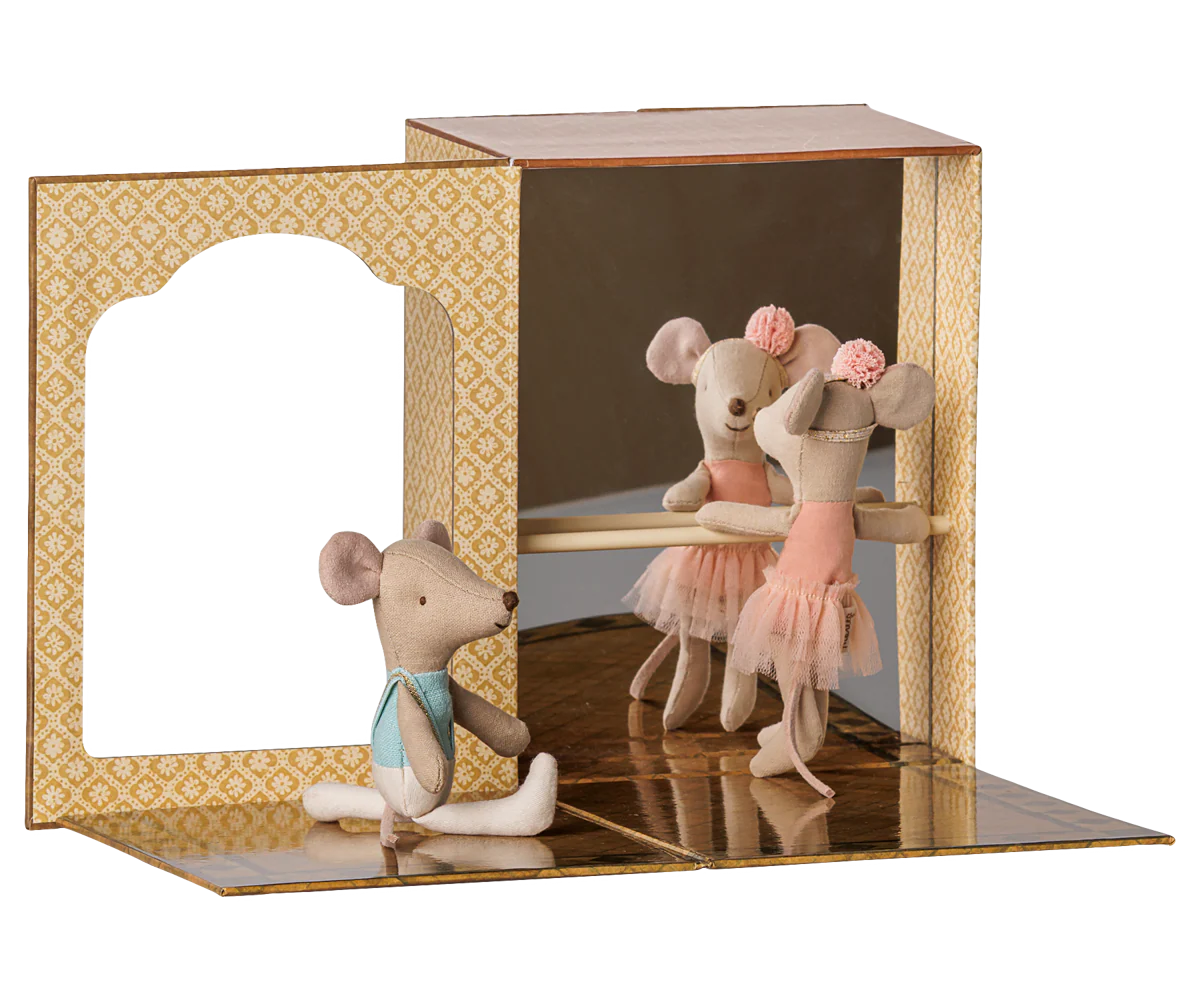 A miniature ballet scene display featuring three small plush mouse ballerina figures. One mouse sits on the floor wearing a light blue bow tie, while another mouse in a pink tutu dances in front of a mirrored backdrop inside a patterned wooden box.