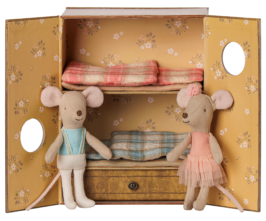 A miniature dollhouse wardrobe with floral yellow doors, two shelves, and a drawer, styled with two plush mouse dolls dressed in pastel clothing.