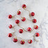 Embossed Red Mercury Glass Ball Ornament Garland on a marble table.