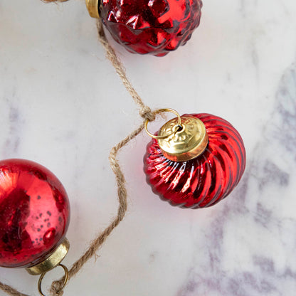 A close up of the Embossed Mercury Glass Ornament showing the swirled detailing and jute cord.