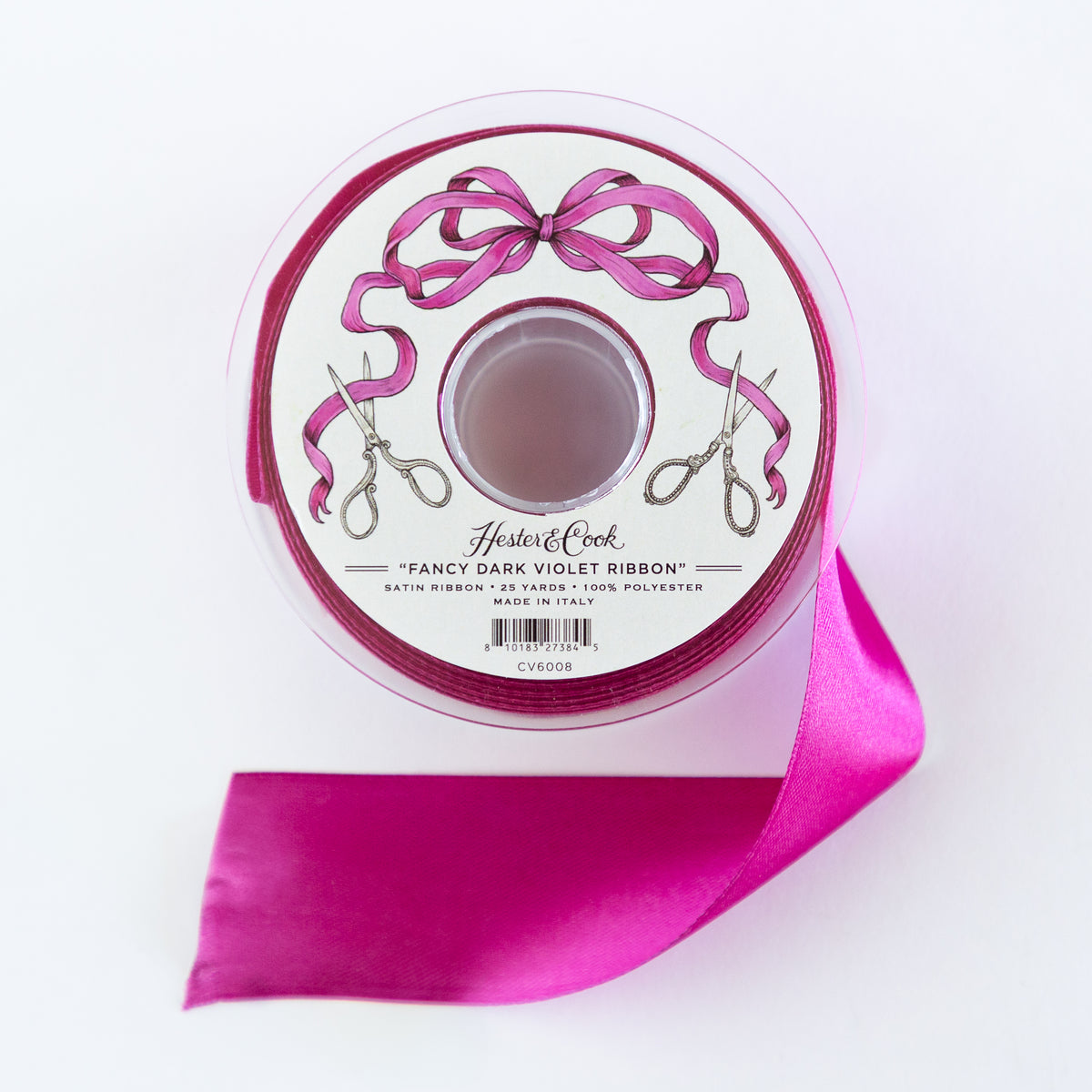 Spool of dark violet ribbon with scissors and a bow design on a white background.
