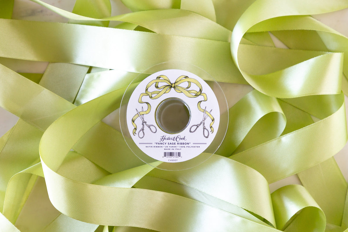 Spool of sage ribbon with a decorative label on a background of sage ribbons.