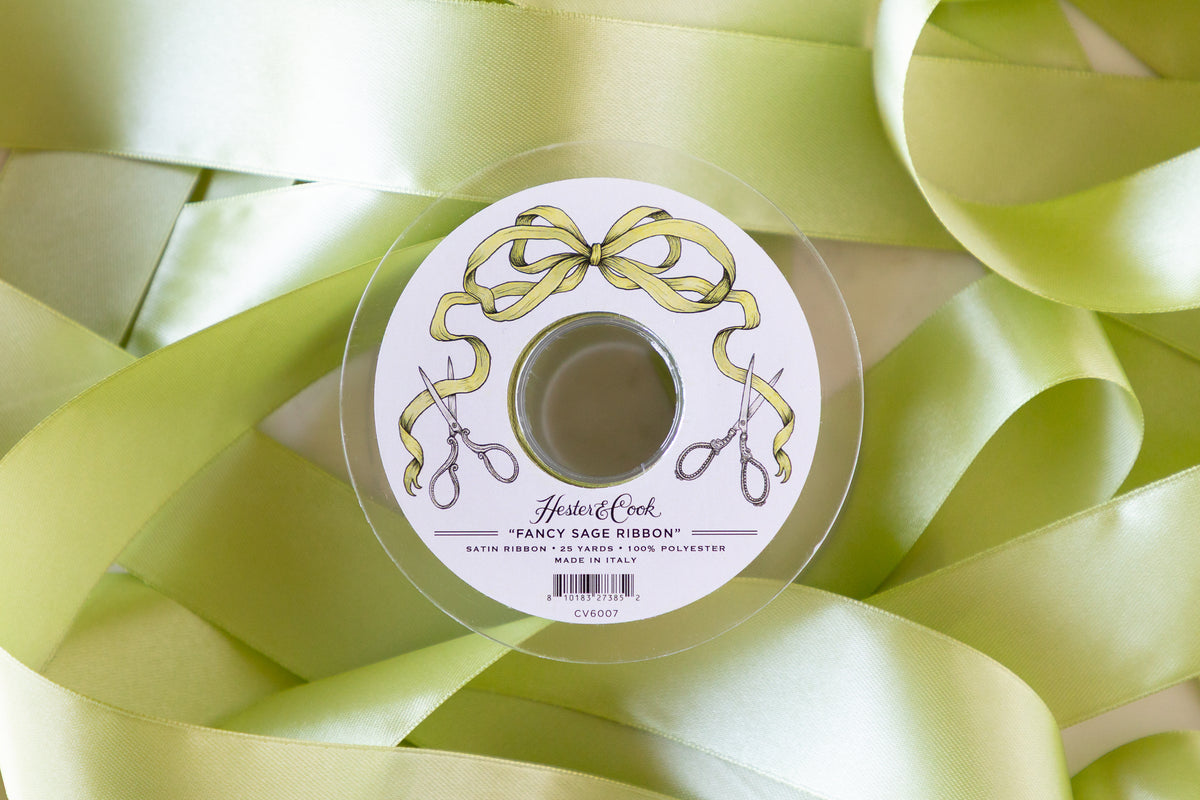 Spool of sage ribbon with a decorative label on a background of sage ribbons.