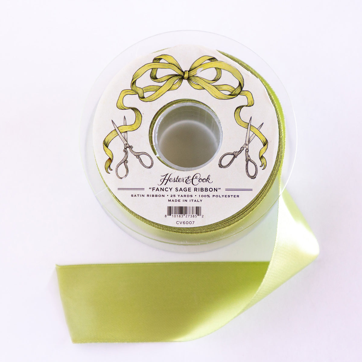 Spool of green ribbon with a decorative label on a white background.
