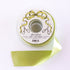 Spool of green ribbon with a decorative label on a white background.