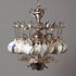 A whimsical chandelier crafted using a vintage silver-plate teapot, sugar/creamers, serving trays and teaspoons, and topped off with assorted vintage teacups.