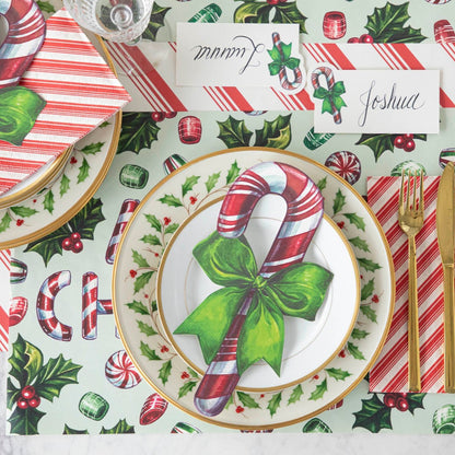 A Christmas candy themed table setting featuring the Candy Cane Table Accent resting on Holly dinner plates.