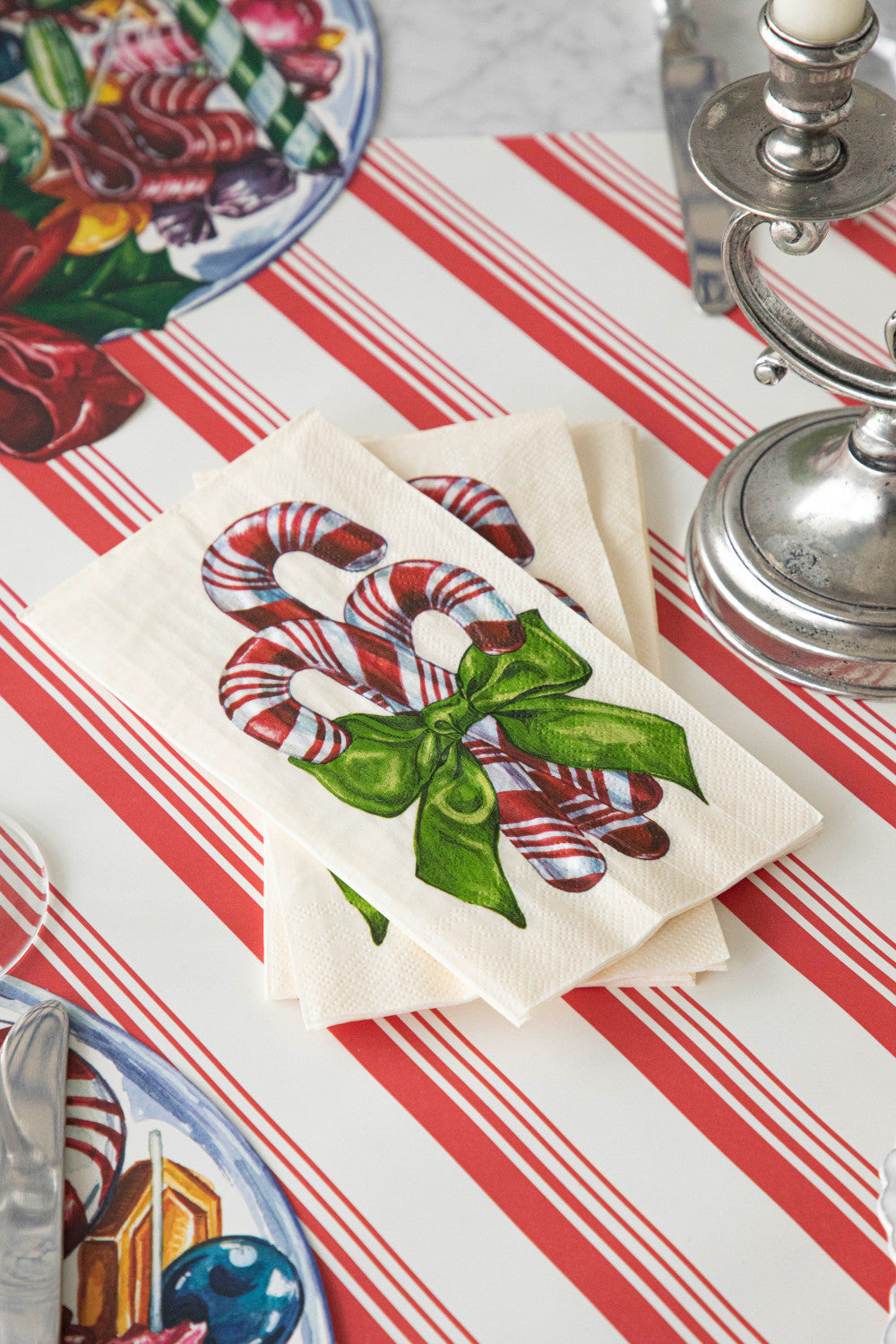 A stack of Candy Cane Guest Napkins on the Peppermint Stripe Runner.