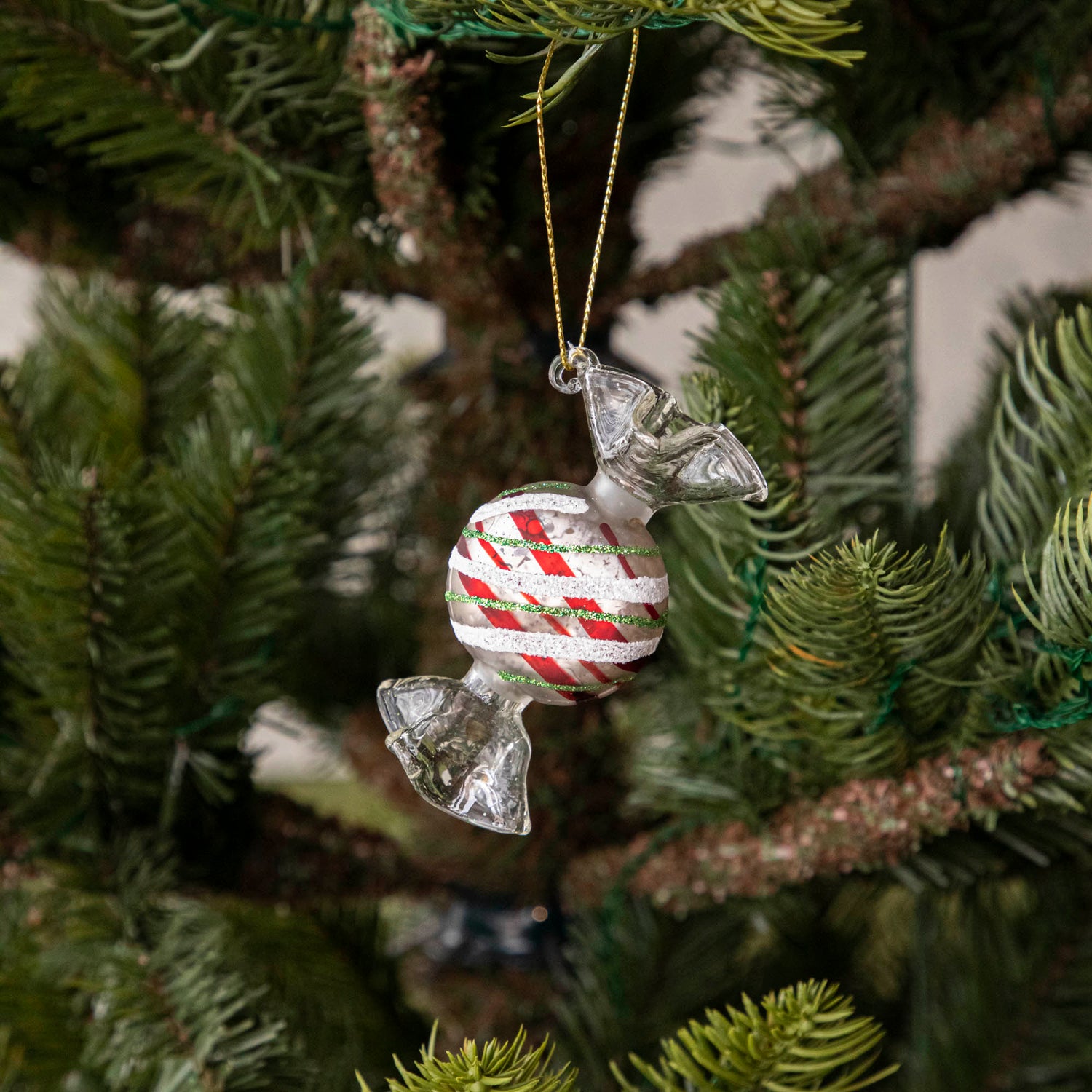 Round Red Plaid Candy Shaped Ornament hanging in a tree