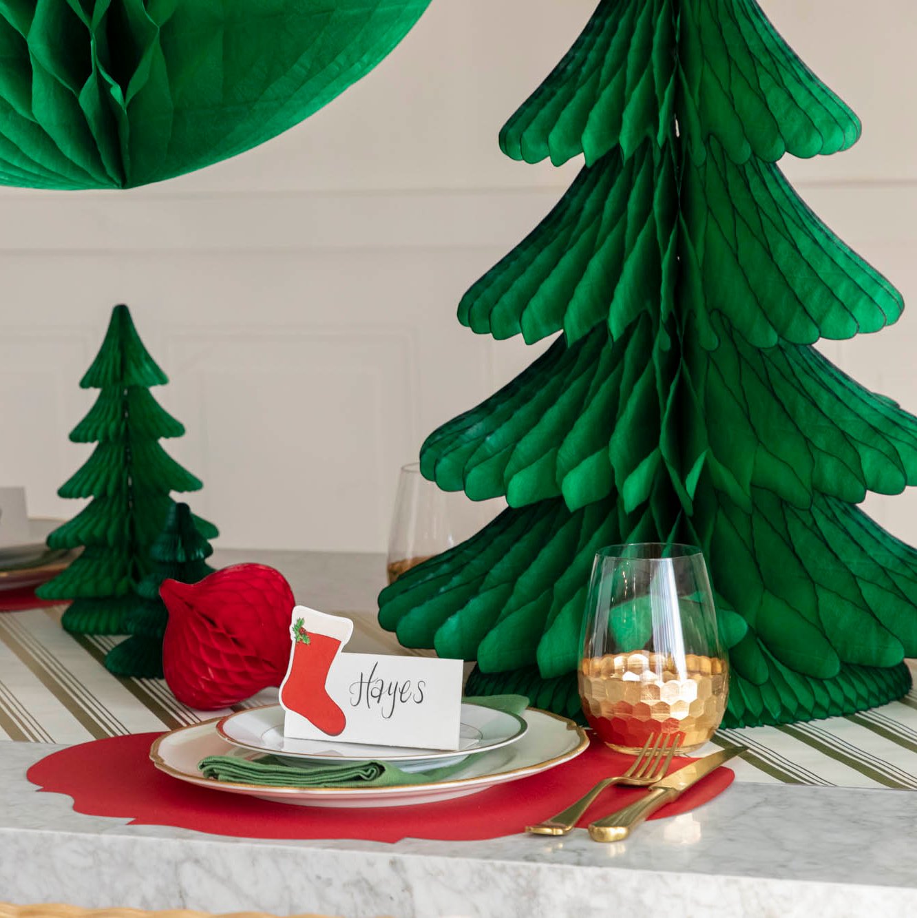 A festive Christmas table setting with the Honeycomb Extra Large Tree behind a place setting.