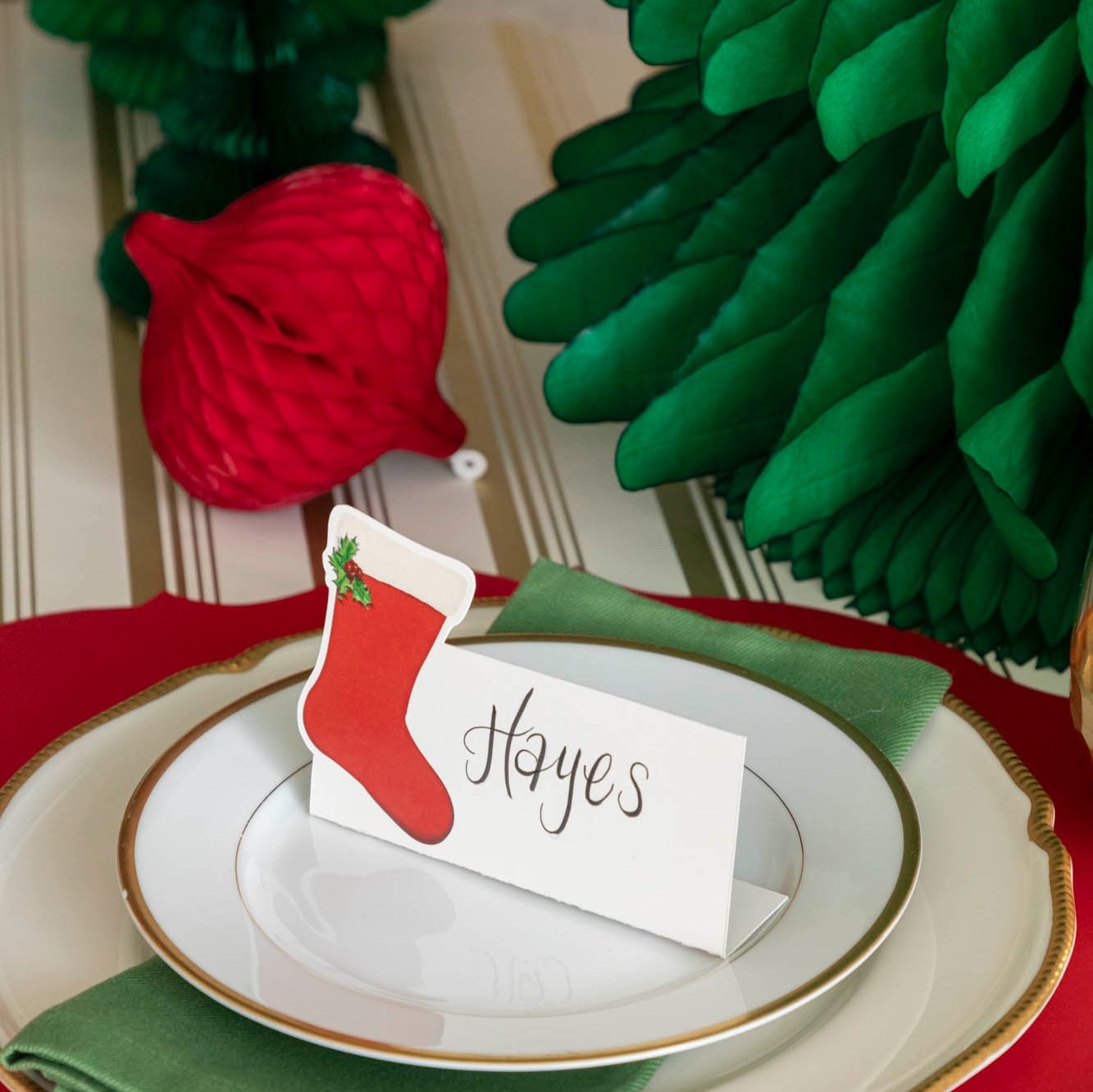 A Christmas place setting with the red, Honeycomb Tapered Ornament behind it.