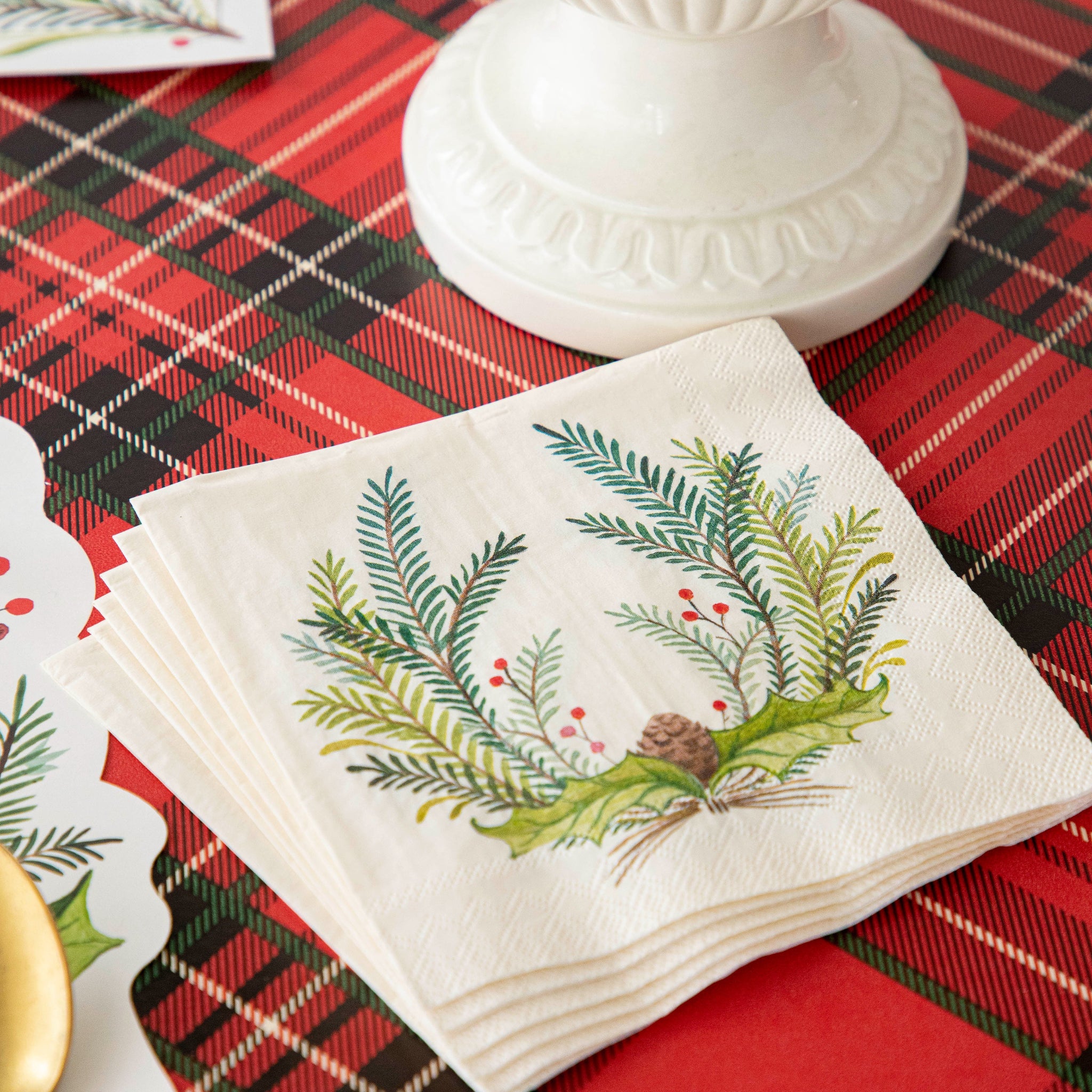 A stack of the Christmas Sprig Cocktail Napkins on the Red Plaid Runner.