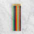 Set of colored pencils with gold caps on a marble surface.